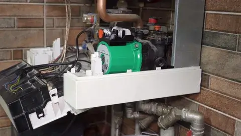 An open boiler unit showing a newly installed central heating pump by a professional plumber in Luton.