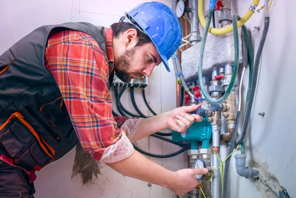 Gas Safe registered heating engineer adjusting central heating manifold valves during a maintenance inspection in Luton.
